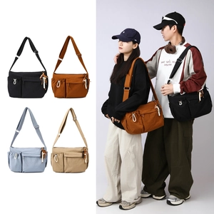 Detail of adjustable strap and decorative beaded charms on this stylish canvas messenger bag