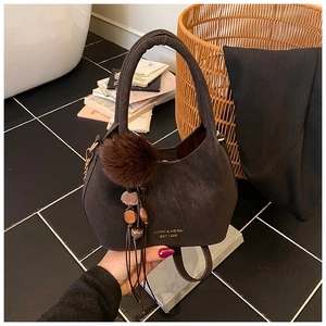Détail de la texture en simili cuir vintage marron foncé avec logo et pompon