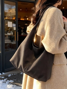 Retro matte brown hobo tote bag with wide shoulder strap in a winter outdoor setting