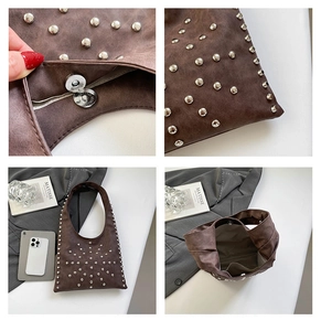Detail of silver rivets and magnetic buckle on dark brown matte underarm bag
