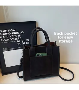 Detail of small crossbody bag back pocket showing a green smartphone storage space