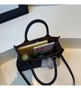 Top view of a black tote bag showing spacious interior with books, phones and water bottle