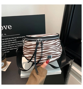 Nahaufnahme der Zebra-Halbmondtasche mit Doppelreißverschluss und silberner Plakette