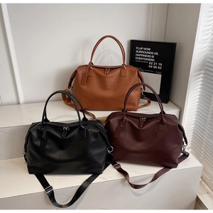 Detailed view of three large matte faux leather tote bags in brown, black, and burgundy