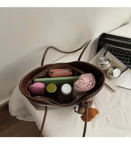 Brown oil wax leather tote interior showing large capacity with daily essentials and tablet