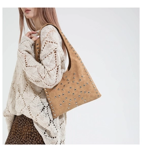 Close-up of brown suede hobo bag with silver rivet studs and vintage bohemian texture