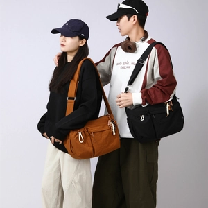 Detail view of large messenger bags in brown and black with adjustable shoulder straps