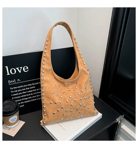 Close-up of khaki leather hobo bag featuring decorative silver rivets in punk retro style
