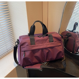 Vue détaillée du sac de voyage violet prune avec bandoulière réglable et poignées robustes
