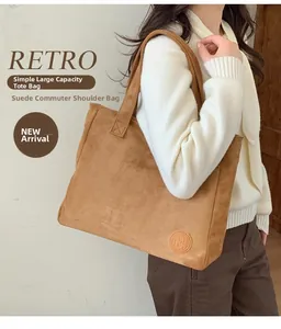 Brown suede tote bag detail featuring large capacity design and embossed circular logo