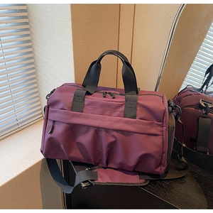 Détail du sac de voyage en toile violet avec bandoulière large et poche zippée