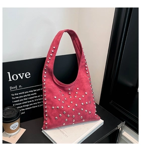 Detail of magenta suede tote bag with silver studs and a stylish hobo shape