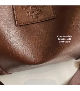 Gros plan sur la texture du cuir marron foncé et l'étiquette embossée sur le sac