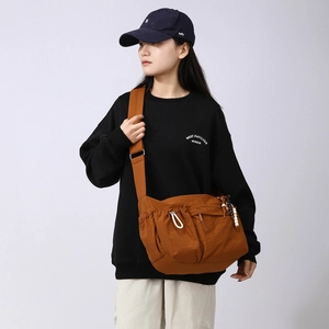 Detailed view of caramel brown crossbody bag with multi-pockets and beaded charms