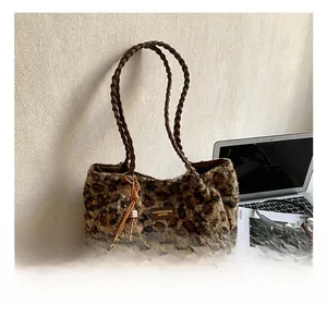 Detailed view of leopard print plush tote bag with woven leather handle and fashion tag
