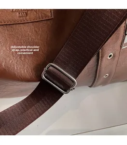 Détail du sac marron avec motif litchi, bandoulière en nylon et boucle argentée réglable