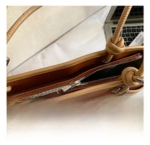 Gedetailleerde close-up van de metalen rits op een tweekleurige tote bag voor dames