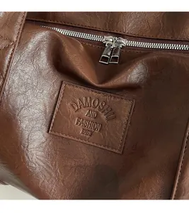 Gros plan de l'étiquette en cuir embossé et du zip en métal argenté sur un sac cabas