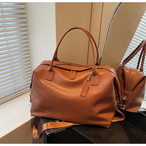 Macro shot of brown leather travel tote bag with metal hardware and spacious interior