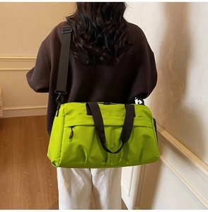 Side view of model carrying a large fluorescent green fitness bag with black straps
