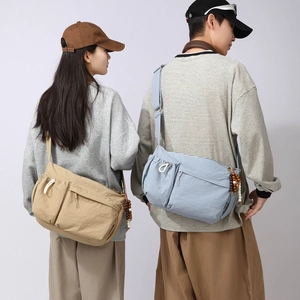 Detail of couple's crossbody bags featuring multiple pockets and bead charms in casual style
