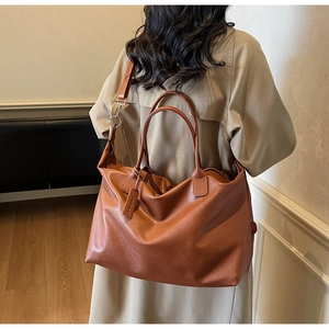 Caramel brown PU leather tote bag with reinforced handles and adjustable shoulder strap