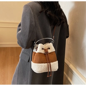 Detail of plush bucket bag with lamb wool and suede contrast, featuring silver metal handle