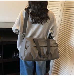 Close-up of durable dark grey travel bag showing reinforced handles and adjustable strap