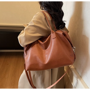 Detailed side view of caramel faux leather tote bag showing soft texture and shoulder strap