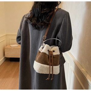 Detail of plush brown and white bucket bag with drawstring on grey wool coat