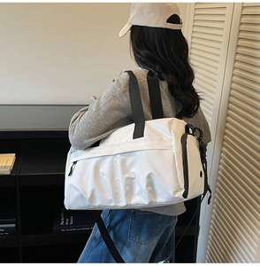 Detailed shot of spacious white nylon travel bag with black straps and side compartment