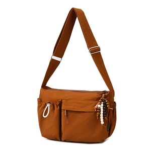 Detail of caramel nylon crossbody bag with multi-pocket design and adjustable strap