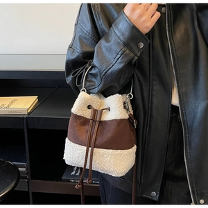 Detail view of contrast fleece bucket bag with metal ring handle and drawstring closure