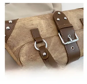 Detailed close-up of retro denim underarm bag featuring silver rivets and leather straps
