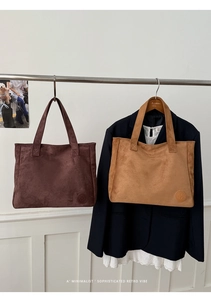 Detail view of large suede tote bags in dark brown and khaki with round embossed logo