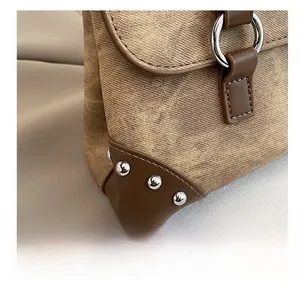 Close-up of retro shoulder bag featuring twill fabric texture and silver rivet details