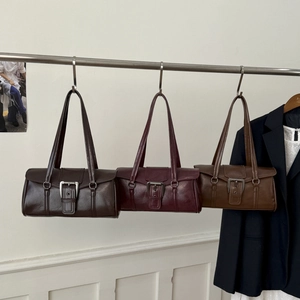 Detailed view of vintage matte leather underarm bags with stylish metal belt buckles