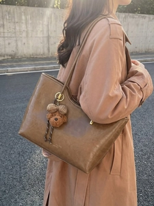 Retro brown oil wax leather tote bag with plush puppy pendant and gold hardware