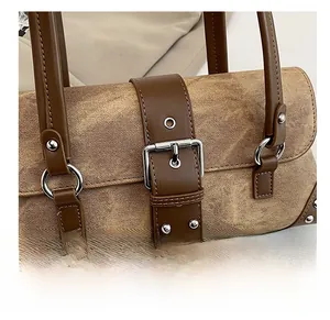 Detail of brown twill texture with leather straps and metallic rivets on a luxury handbag