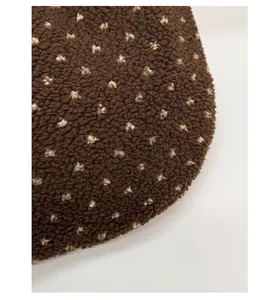 Detailed texture of brown teddy fleece fabric with vintage cream spotted patterns