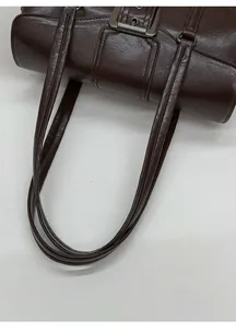 Detailed view of dark brown textured leather shoulder bag with vintage silver metal buckle