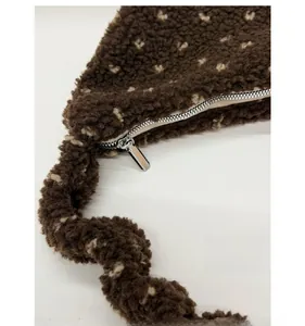 Detail of silver metal zipper and soft brown plush fabric on a vintage tote bag