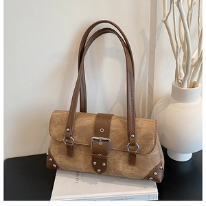 Detail of vintage rivet shoulder bag with metal buckle on minimalist background