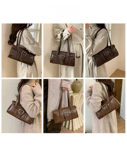 Close-up of retro brown shoulder bag with large metal buckle detail on textured faux leather