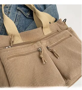 Détail de fermetures éclair fluides et tirettes sur sac cabas en velours côtelé kaki