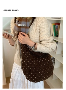 Close-up of fluffy polka dot tote bag and wool scarf styled with a cable knit sweater