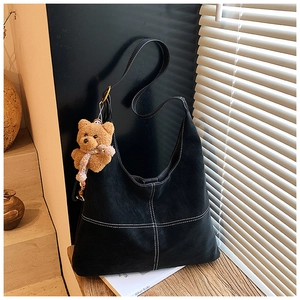 Dettaglio della grande borsa tote vintage nera con cuciture bianche e orsetto