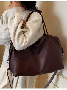 Large dark brown leather travel tote bag with pebble texture and adjustable shoulder strap