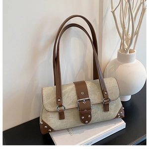 Close-up of vintage rivet shoulder bag showing textured olive canvas and metal buckles