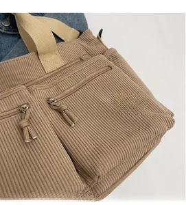 Détail du sac fourre-tout en velours côtelé marron clair avec poches zippées devant